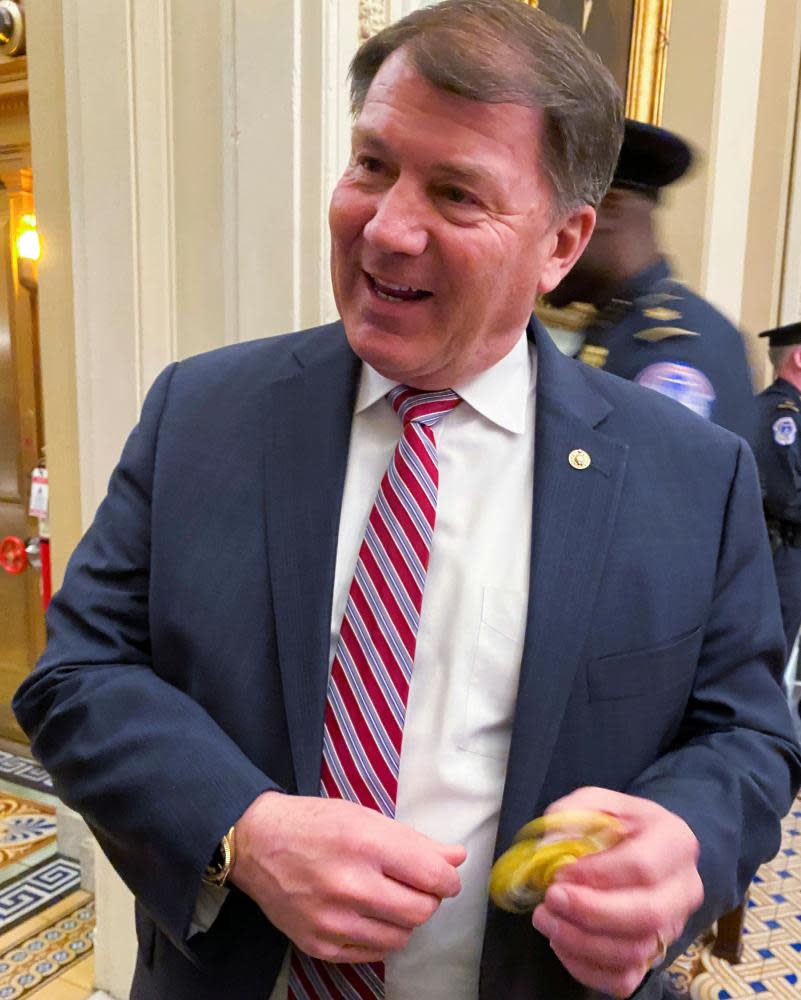 Senator Mike Rounds plays with a fidget spinner handed out to Republican senators at lunch to keep them occupied during the Senate impeachment trial.