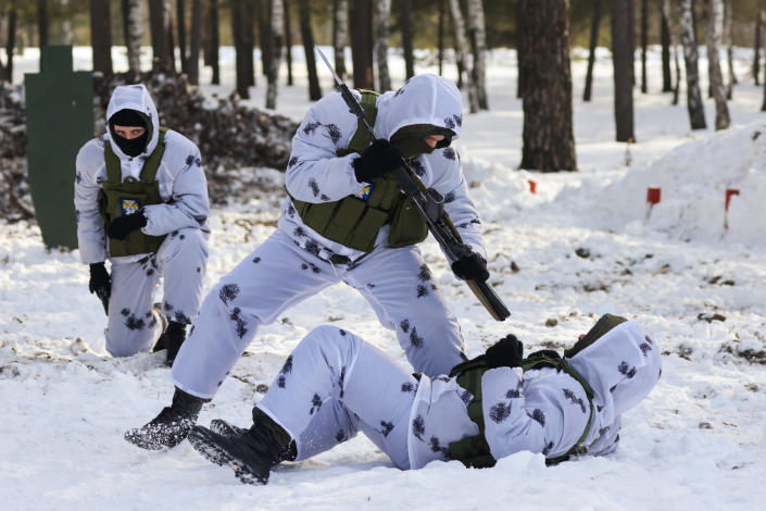 Students wearing camouflage undergo military and sports training in the snow. 