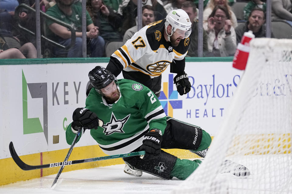 Dallas Stars defenseman Jani Hakanpaa (2) is pulled down to the ice by Boston Bruins left wing Nick Foligno (17) in the second period of an NHL hockey game, Tuesday, Feb. 14, 2023, in Dallas. Foigno was issued a penalty for holding on the play. (AP Photo/Tony Gutierrez)