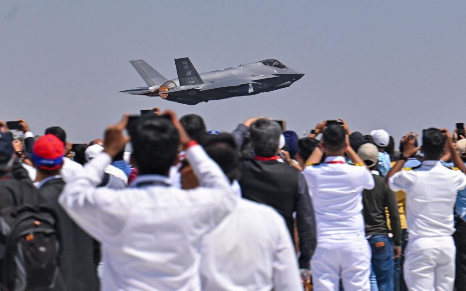 Spectators watch as a US Air Force's (USAF) fifth-generation supersonic multirole F-35 fighter jet flies past during a flying display on the second day of the 14th edition of Aero India 2023 - MANJUNATH KIRAN/AFP via Getty Images