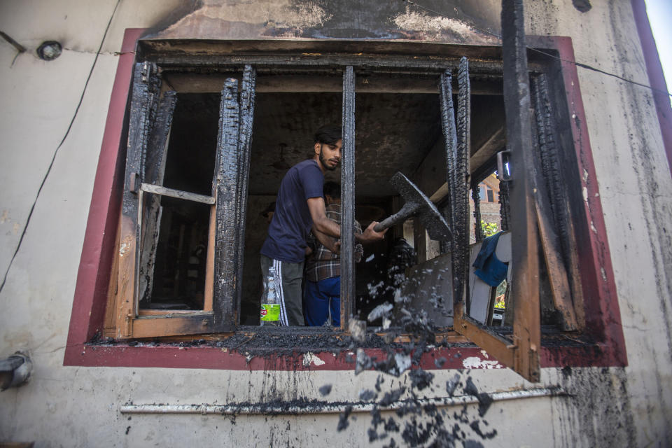 A Kashmiri man removes debris from a damaged house after the gunbattle in Srinagar, Indian controlled Kashmir, Thursday, Sept. 17, 2020. The gunfight erupted shortly after scores of counterinsurgency police and soldiers launched an operation based on a tip about the presence of militants in a Srinagar neighborhood, Pankaj Singh, an Indian paramilitary spokesman, said. (AP Photo/Mukhtar Khan)