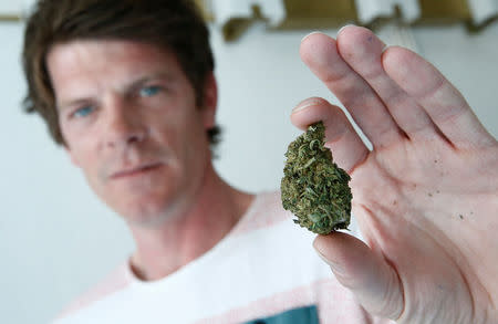 Paul Monot, co-founder of Dr Green, holds dried cannabis in his shop in Lausanne, Switzerland March 17, 2017. REUTERS/Denis Balibouse