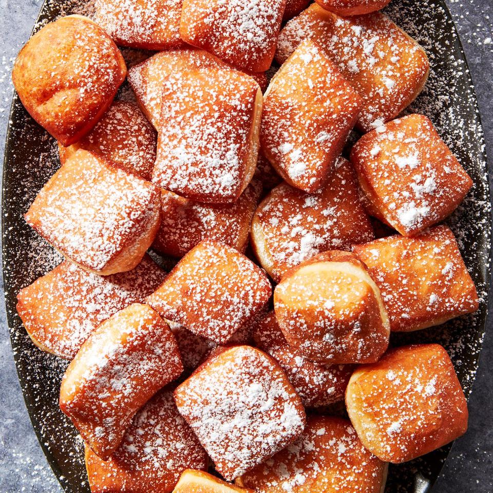 beignets on a platter dusted with powdered sugar