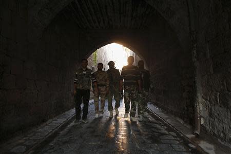Free Syrian Army fighters walk with their weapons in old Aleppo, October 27, 2013. REUTERS/Hamid Khatib