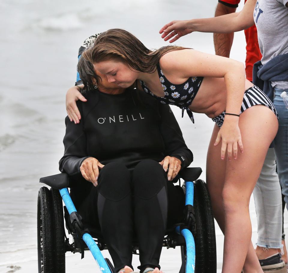 Colleen Ryan, 11, gives a hug to Lin Schott, who is her grandmother and also a veteran. The two surfed on the same board as part of the Wounded Warrior Project at Hampton’s North Beach Friday, Aug. 26, 2022.