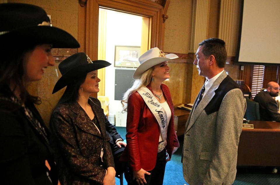 In this Jan. 22, 2014 photo, Colorado state representative Jerry Sonnenberg (R-Sterling) talks with Miss Rodeo America Paige Nicholson, inside the chambers of the Colorado State Legislature, at the Capitol, in Denver. Nicholson and fellow rodeo queens Codi Miller, center, and Ashley Fuchs were in town for the National Western Stock Show. Sonnenberg, a rancher who’s the only farmer in the Colorado House, plans to push a radical idea this session: give each of his state’s 64 counties one House seat apiece instead of electing representatives from districts with equal populations. ( AP Photo/Brennan Linsley)