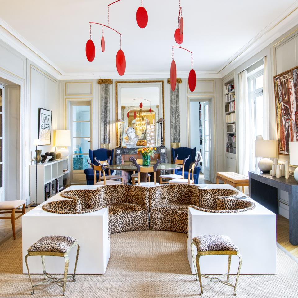 The main salon was decorated in the 1950s by the decorating firm Maison Jansen. The large white and animal print safari sofa is by the Italian design studio Archizoom from 1968. The iron stools are by Italian designer Pier Luigi Colli circa 1950. The ceiling mobile is by British artist Marc Cavell. In the background is a dining room table by Italian architect Carlo di Carli, and the armchairs are by Christian Lacroix.