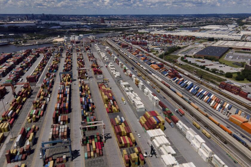 Shipping containers are stacked together at the Port of Baltimore, Friday, Aug. 12, 2022, in Baltimore. (AP Photo/Julio Cortez)