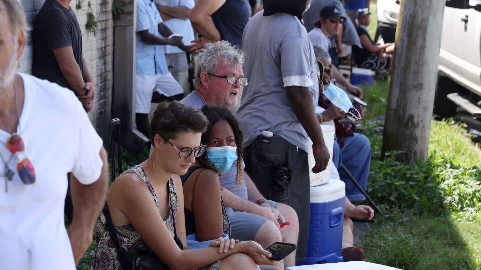 People wait in extreme heat to buy ice at Duplantier Ice Service in New Orleans, Louisiana on September 1, 2021, as power was out in most of the city after Hurricane Ida tore through the state. - Leah Millis/Reuters