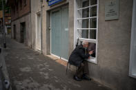 Javier Anto, 90, speaks to his wife Carmen Panzano, 92, through the window separating the nursing home from the street in Barcelona, Spain, Wednesday, April 21, 2021. Since the pandemic struck, a glass pane has separated _ and united _ Javier and Carmen for the first prolonged period of their six-decade marriage. Anto has made coming to the street-level window that looks into the nursing home where his wife, since it was closed to visits when COVID-19 struck Spain last spring. (AP Photo/Emilio Morenatti)