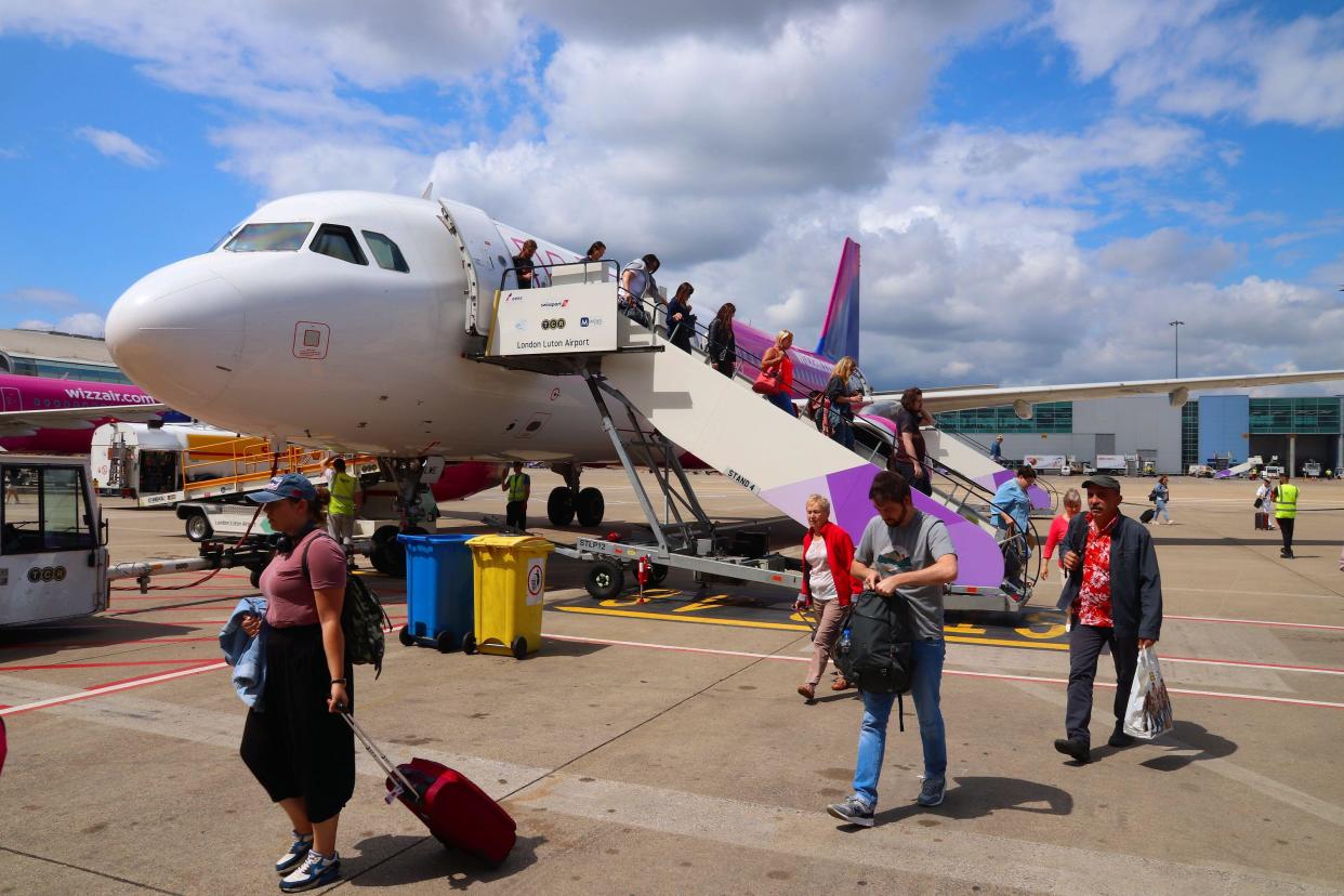 airline LUTON, UK - JULY 12, 2019: Passengers disembark Wizz Air Airbus A320 low coast plane at London Luton Airport in the UK. It is UK's 5th busiest airport