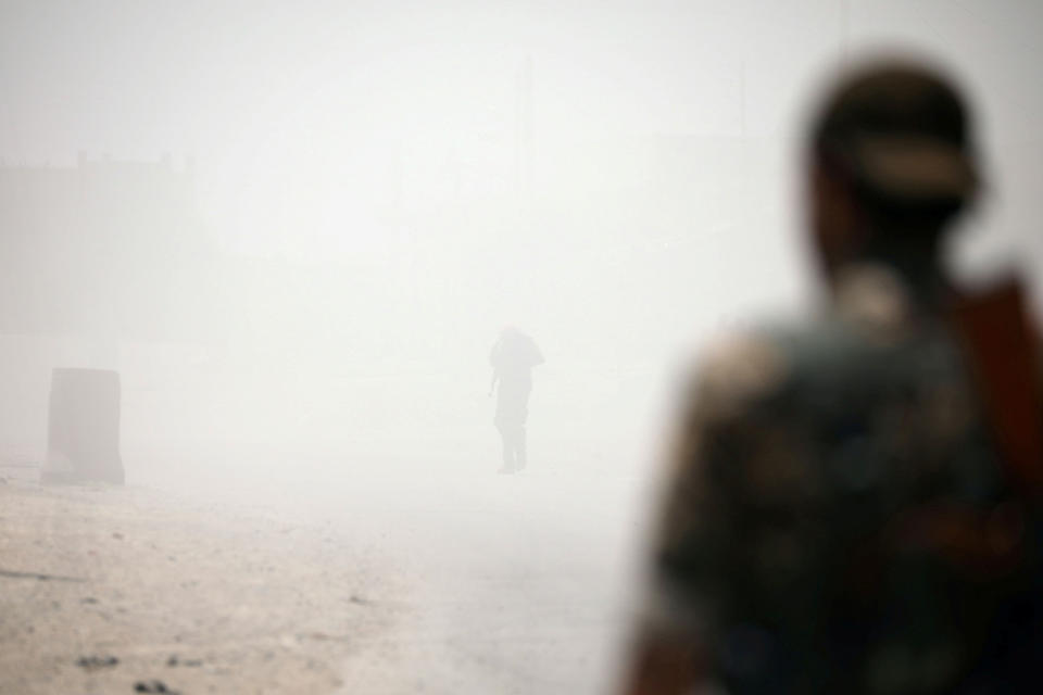 SDF fighters stand amid smoke