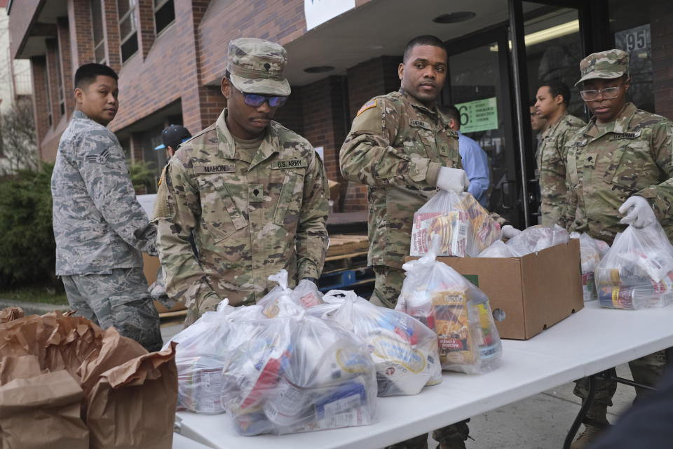 Members of the New York National Guard help to organize and distribute food to families on free or reduced school lunch programs in New Rochelle, N.Y., Thursday, March 12, 2020. State officials have set up a “containment area” in the New York City suburb, where schools and houses of worship are closed within a 1-mile radius of a point near a synagogue where an infected person with coronavirus had attended events. State officials stress it is not a lockdown. The vast majority of people recover from the new coronavirus. According to the World Health Organization, most people recover in about two to six weeks, depending on the severity of the illness. (AP Photo/Seth Wenig)