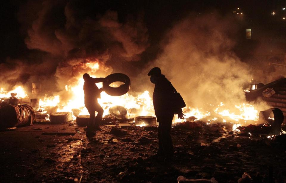 Anti-government protesters clash with riot police in Kiev's Independence Square, the epicenter of the country's current unrest, Kiev, Ukraine, Tuesday, Feb. 18, 2014. Thousands of police armed with stun grenades and water cannons attacked the large opposition camp in Ukraine's capital that has been the center of nearly three months of anti-government protests on Tuesday, after at least nine people were killed in street clashes. (AP Photo/Sergei Chuzavkov)