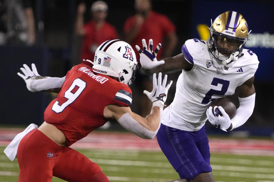 Washington wide receiver Ja'Lynn Polk (2) runs as Washington cornerback Thaddeus Dixon (9) defends during the first half of an NCAA college football game, Saturday, Sept. 30, 2023, in Tucson, Ariz. (AP Photo/Rick Scuteri)