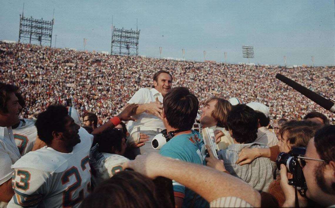 Dolphins coach Don Shula is carried off the field by many, including Nick Buoniconti, after the Dolphins Super Bowl VII win that finished the 17-0 Perfect Season. Running back Charlie Leigh (23) is in the foreground.