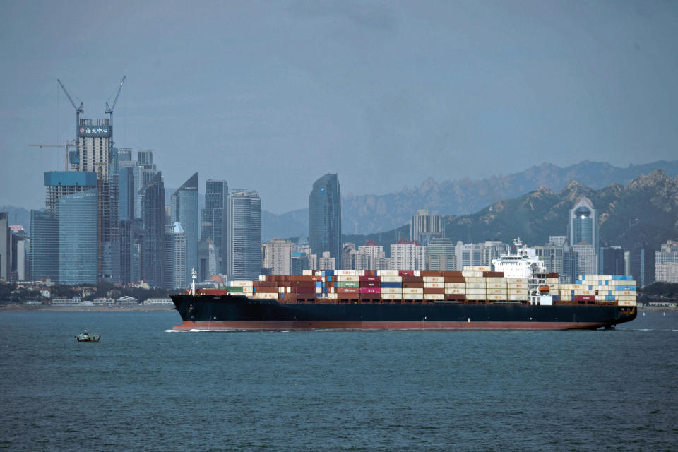 FILE - In this Sept. 13, 2018, file photo, a container ship sails by the business district in Qingdao in east China's Shandong province. U.S.-Chinese trade contracted again in October, despite optimism about possible progress in talks aimed at ending a tariff war that threatens global economic growth. Chinese imports of U.S. goods fell 14.3% from a year earlier to $9.4 billion, customs data showed Friday, Nov. 8, 2019. (Chinatopix via AP, File)