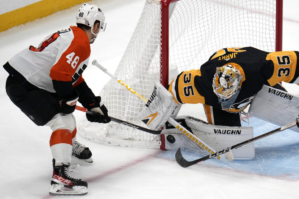 Pittsburgh Penguins goaltender Tristan Jarry (35) blocks a shot by Philadelphia Flyers' Morgan Frost (48) during the first period of an NHL hockey game in Pittsburgh, Saturday, Dec. 2, 2023. (AP Photo/Gene J. Puskar)