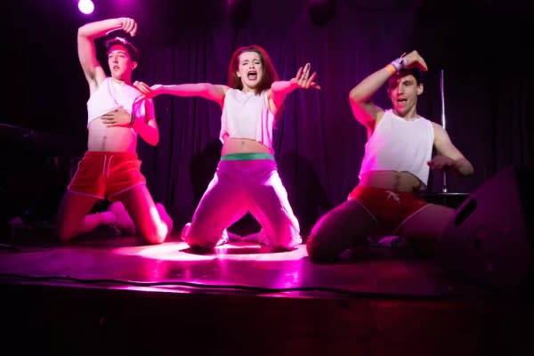 Photo from the Candlelight Cabaret featuring three dancers dressed in white on a stage.