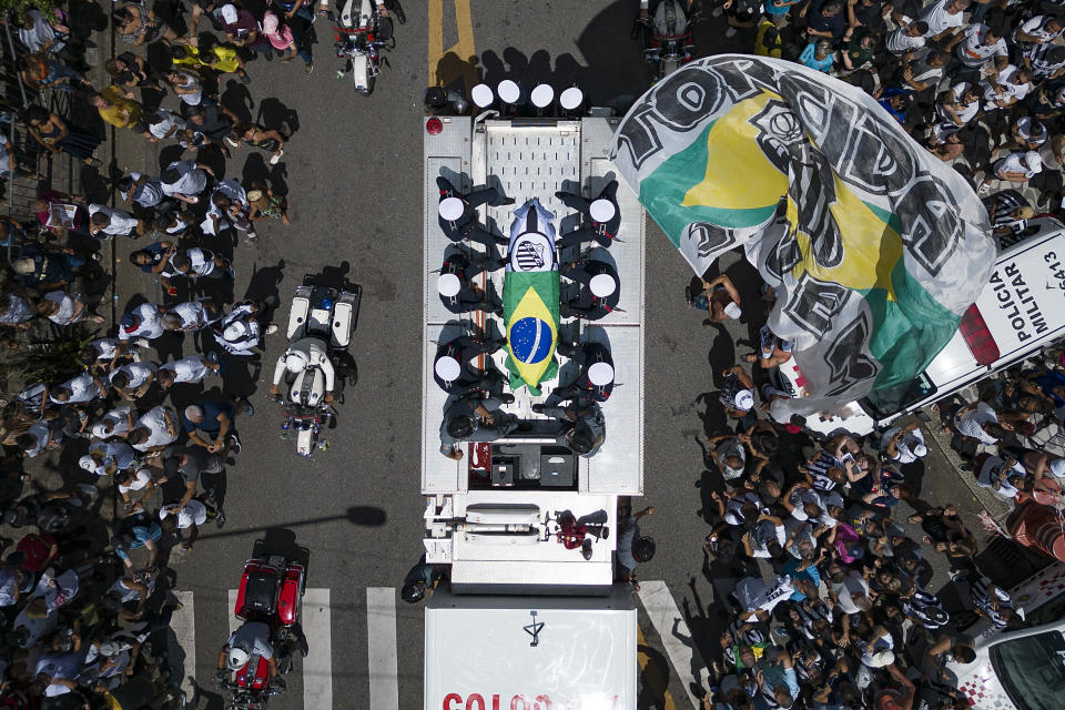 El féretro de Pelé, envuelto en la bandera brasileña, es llevado por ls calles de Santos, Brasil, el martes 3 de enero de 2023 (AP Foto/Matias Delacroix)