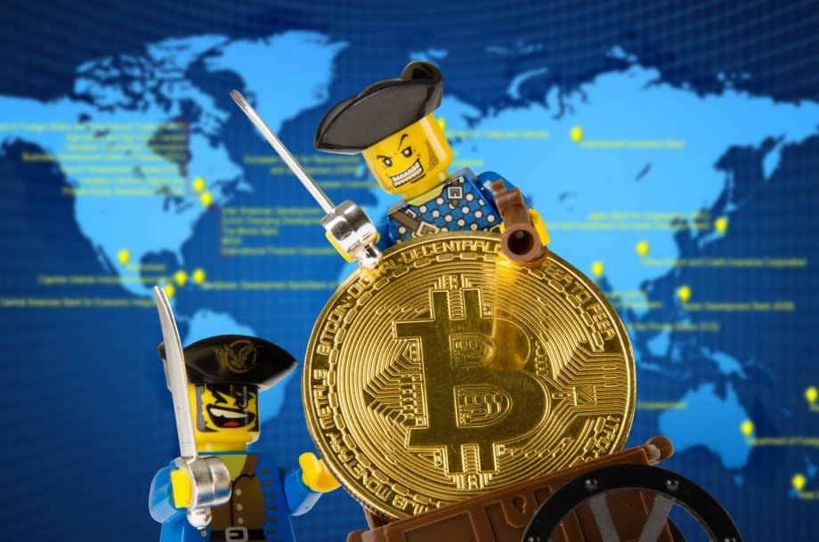 Lego-Piraten mit Bitcoin-Münze vor Weltkarte