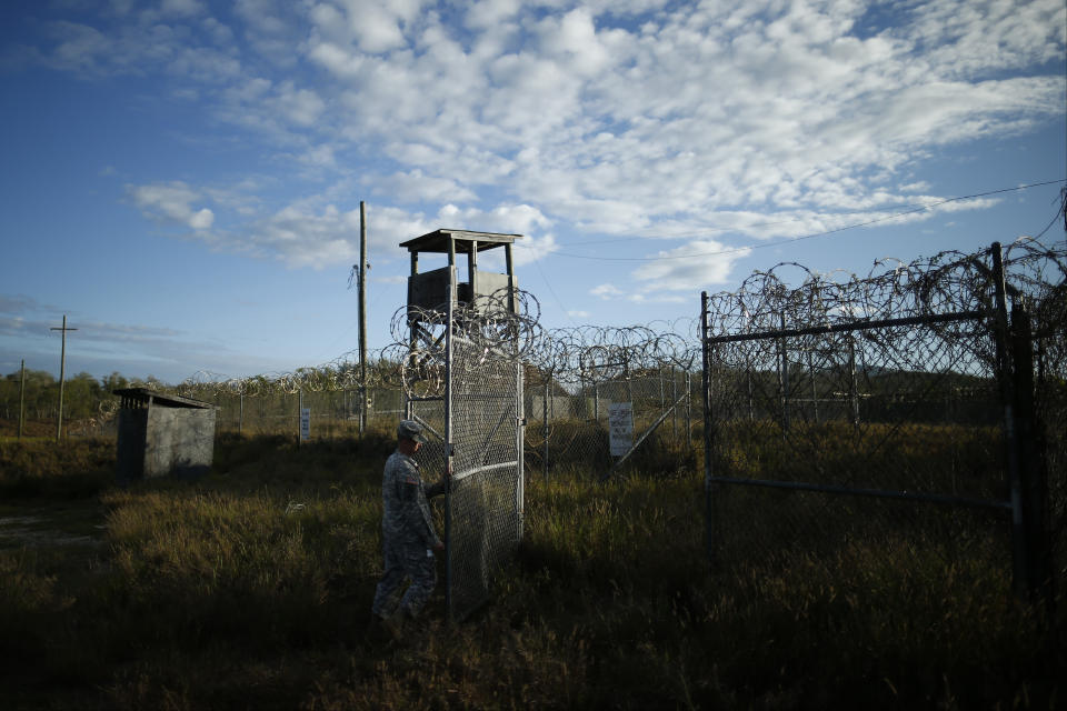 FILE - In this Nov. 21, 2013, file photo reviewed by the U.S. military, a soldier closes the gate at the now abandoned Camp X-Ray, which was used as the first detention facility for al-Qaida and Taliban militants who were captured after the Sept. 11 attacks at Guantanamo Bay Naval Base, Cuba. Detainees were housed in open air pens until the completion of Camp Delta in April 2002. Many detainees at Guantanamo Bay may be closer to heading home under a bipartisan deal reached in Congress that gives President Barack Obama a rare victory in his fight to close the prison for terror suspects. The White House says it intends to shutter the prison on the U.S. base in Cuba, which opened in January 2002 and where most of the 39 men still held have never been charged with a crime. (AP Photo/Charles Dharapak, File)