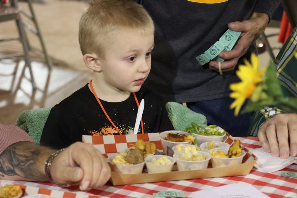 Axel Reece is amazed at the mac and cheese choices at the Hope and Healing Place's annual The Big Cheese macaroni and cheese competition at the Rex Baxter Building Friday evening.