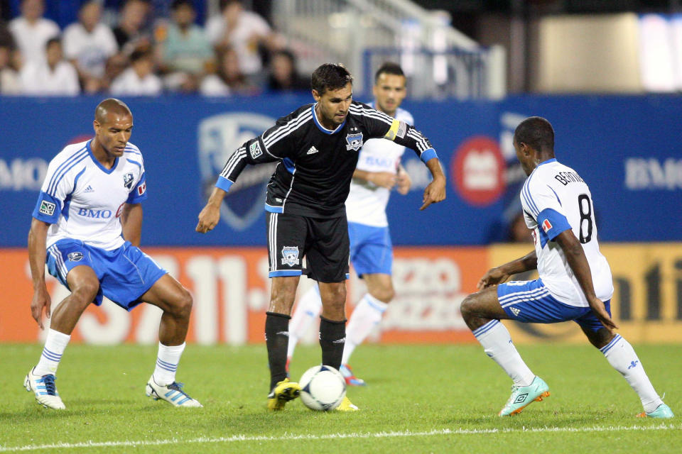 MONTREAL, CANADA - AUGUST 18: Chris Wondolowski #8 of the San Jose Earthquakes moves the ball past Patrice Bernier #8 and Matteo Ferrari #13 of the Montreal Impact during the match at the Saputo Stadium on August 18, 2012 in Montreal, Quebec, Canada. The Impact defeated the Earthquakes 3-1. (Photo by Richard Wolowicz/Getty Images)