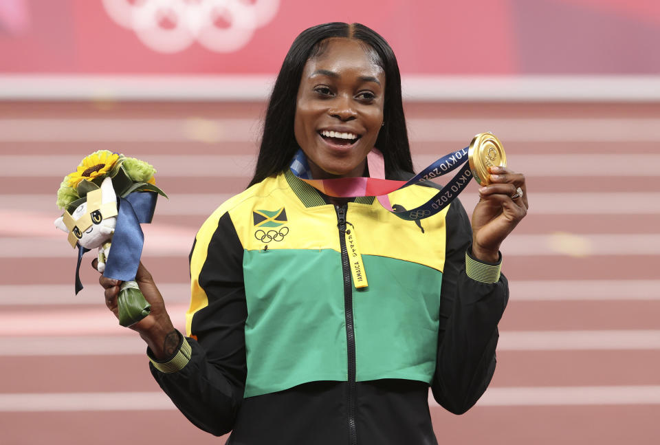 Elaine Thompson-Herah poses with gold medal