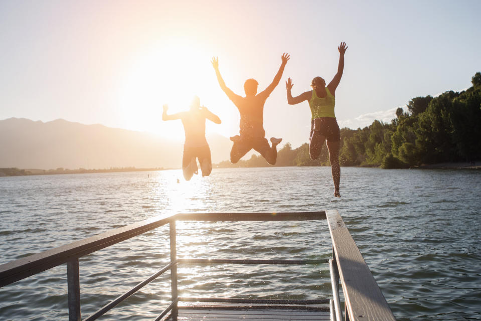 Friends jumping into a lake together