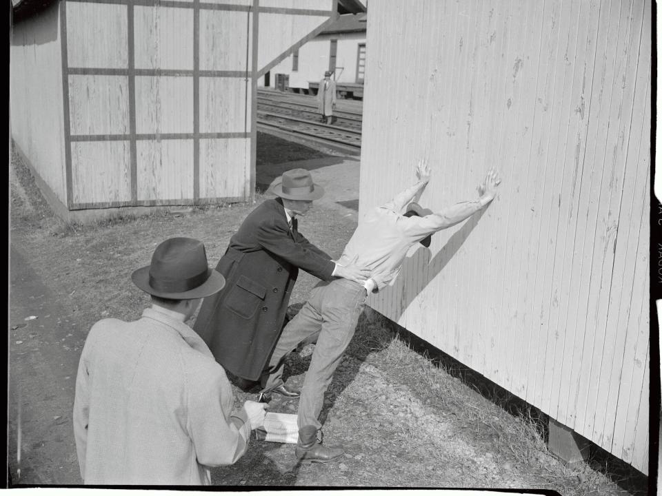 FBI agents conducting a routine pat down of a suspect.