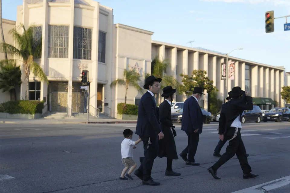Men walk across the Congregation Shaarei Tefila synagogue in Los Angeles Saturday, Oct. 7, 2023. (AP Photo/Damian Dovarganes)