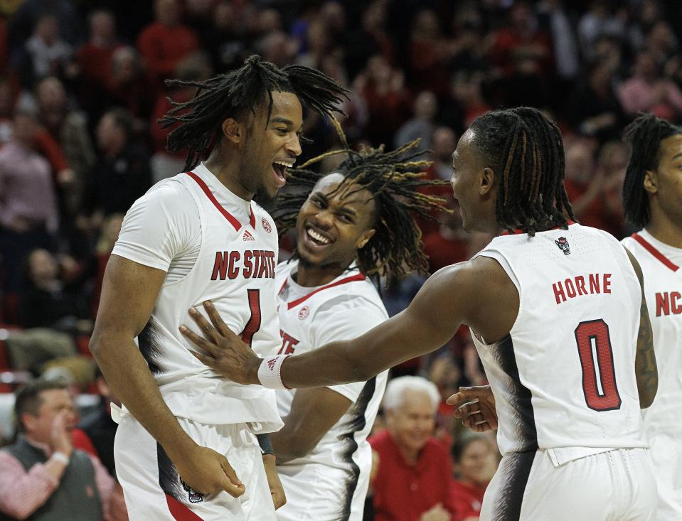 North Carolina State's Jayden Taylor celebrates with Kam Woods and DJ Horne late inthe second half of the team's NCAA college basketball game against Wake Forest on Tuesday, Jan. 16, 2024, in Raleigh, N.C. (Kaitlin McKeown/The News & Observer via AP)