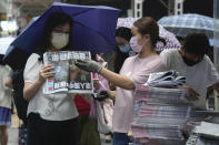 People queue up to buy last issue of Apple Daily at a newspaper booth at a downtown street in Hong Kong, Thursday, June 24, 2021. Hong Kong’s sole remaining pro-democracy newspaper has published its last edition. Apple Daily was forced to shut down Thursday after five editors and executives were arrested and millions of dollars in its assets were frozen as part of China’s increasing crackdown on dissent in the semi-autonomous city. ( AP Photo/Vincent Yu)