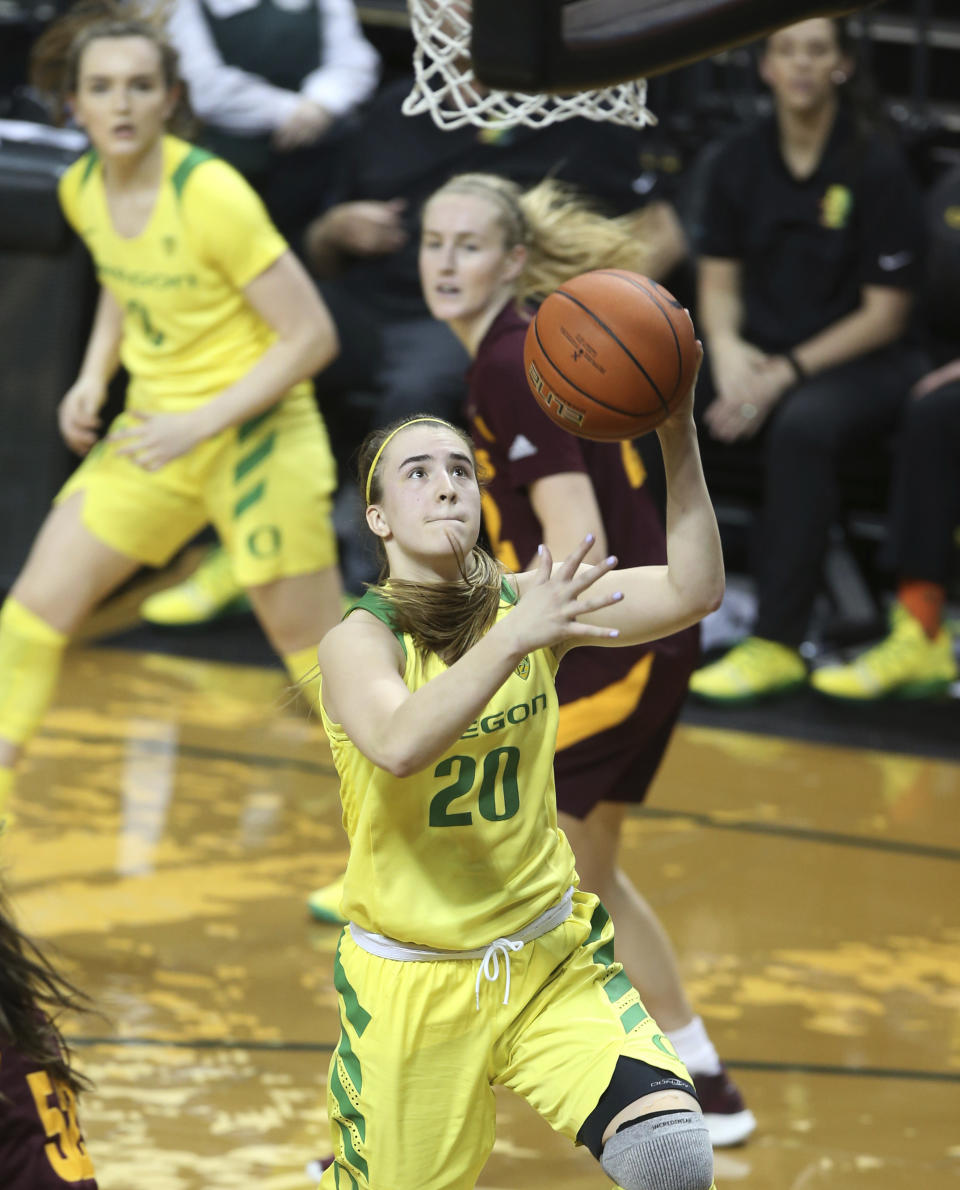 Oregon's Sabrina Ionescu, center, goes up for a shot ahead of teammate Taylor Chavez, left, and Arizona State's Courtney Ekmark during the fourth quarter of an NCAA college basketball game Friday, Jan 18, 2019, in Eugene, Ore. (AP Photo/Chris Pietsch)