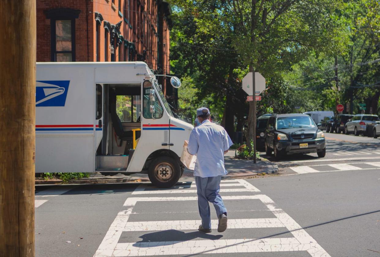 Image: A USPS mail carrier picks up mail from the mailbox on Pavonia Ave. and Coles St. in Jersey City on Aug. 18, 2020. (Calla Kessler / for NBC News)