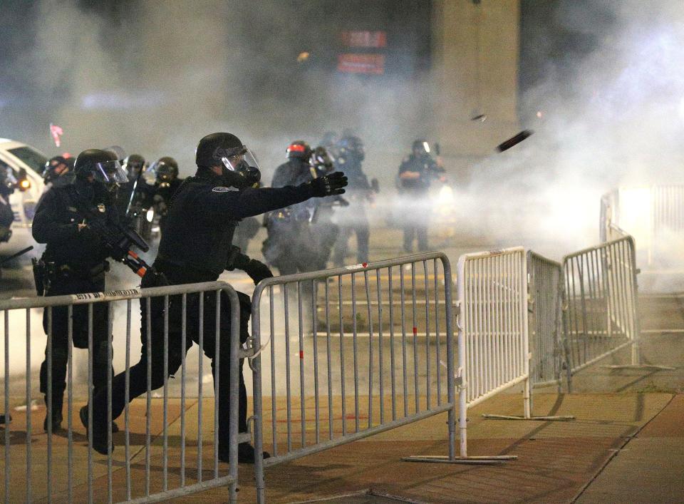 Police toss tear gas toward demonstrators in downtown Rochester, New York.