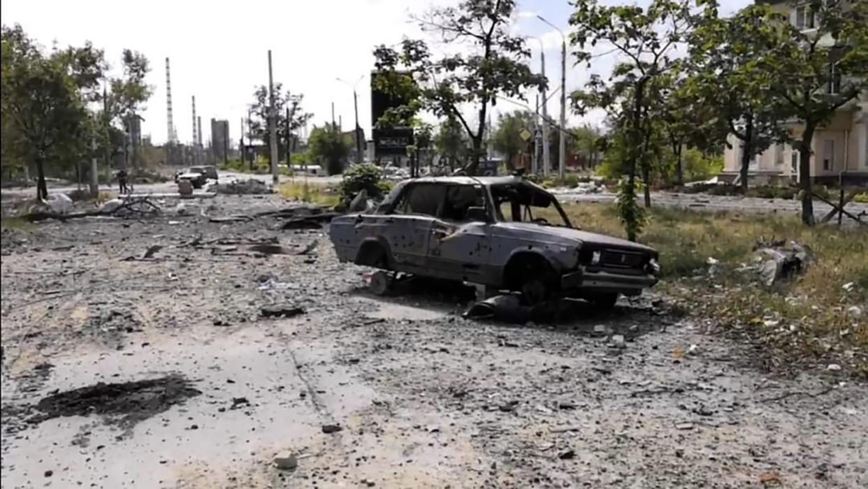 In this photo provided by the Luhansk region military administration, burned car and damaged residential buildings are seen in Lysychansk, Luhansk region, Ukraine, early Sunday, July 3, 2022.