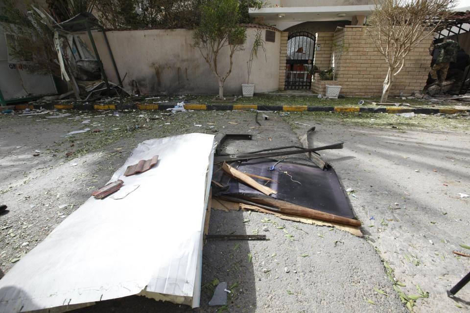 A general view of the damage caused by a bomb blast is seen at the gate of the Iranian ambassador's residence in Tripoli