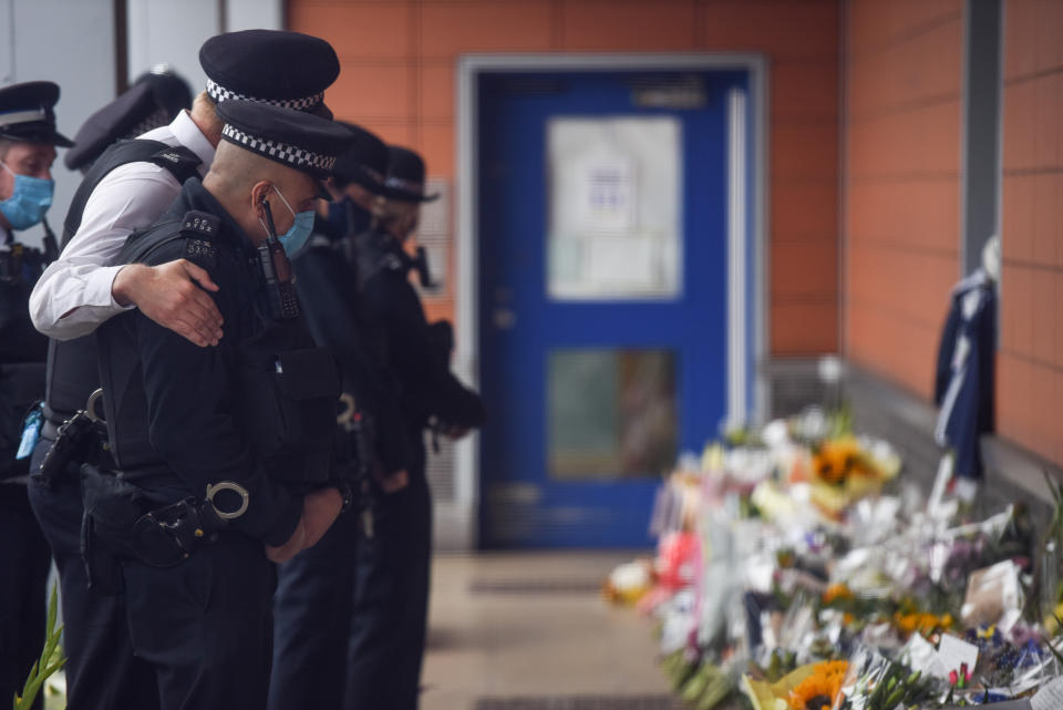 CROYDON, ENGLAND - SEPTEMBER 27: A Police officer comforts a colleague while paying tribute to Sergeant Matiu Ratana outside Croydon Custody Centre on September 27, 2020 in Croydon, England. Metropolitan Police Custody sergeant Matiu Ratana, 54, was shot dead in the early hours of Friday 25 September At Croydon Custody Suite. A handcuffed man being checked in by Sgt Ratana opened fire before turning the weapon on himself. Sgt Ratana died later in hospital. (Photo by Peter Summers/Getty Images)