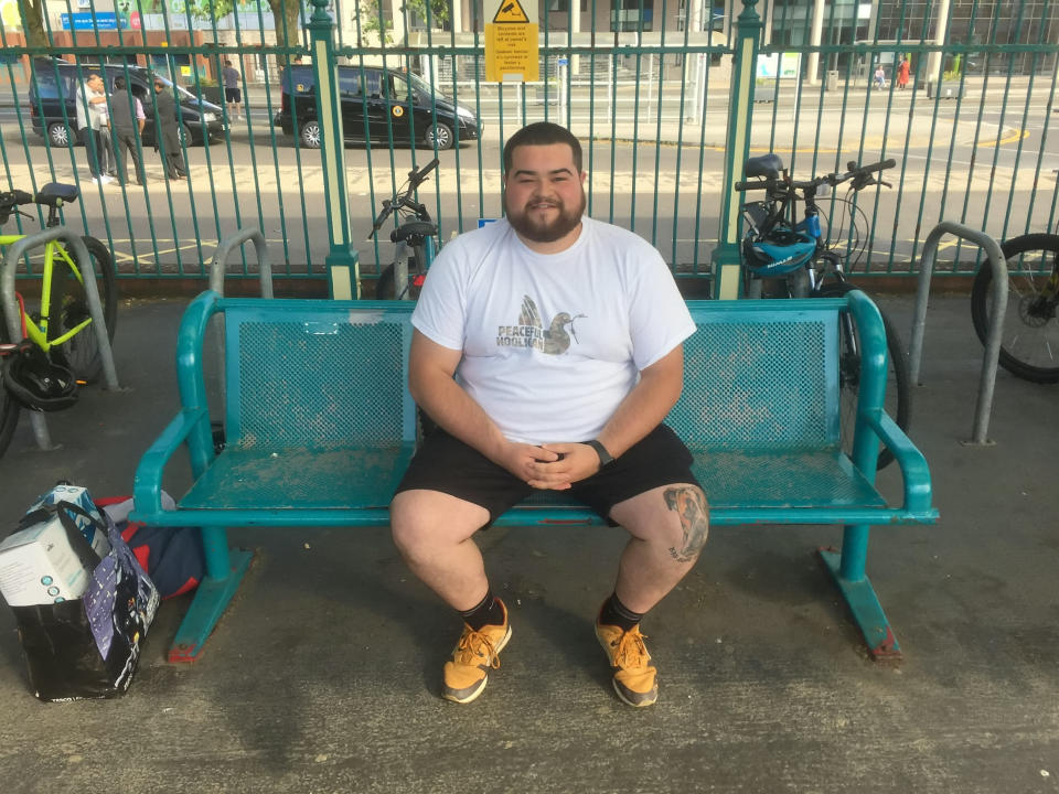 Sam Wilmot sitting on a bench at Newport Railway Station, Wales. (SWNS)