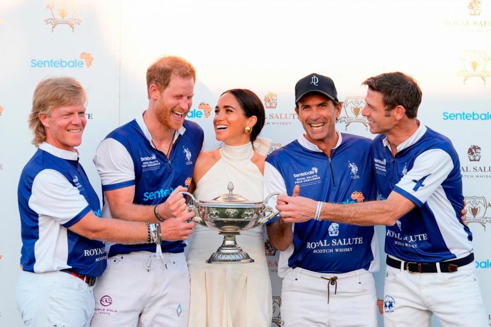 PHOTO: Britain's Prince Harry and wife Meghan Markle, Duchess of Sussex, laugh together as she presents him and his polo teammates with the trophy for winning the 2024 Royal Salute Polo Challenge on April 12, 2024, in Wellington, Fla.  (Rebecca Blackwell/AP)