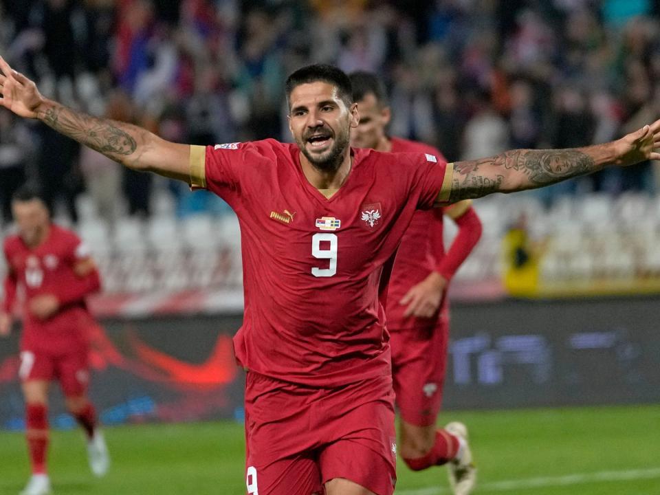 Aleksandar Mitrovic runs with his arms out in celebration during a Serbia soccer match.
