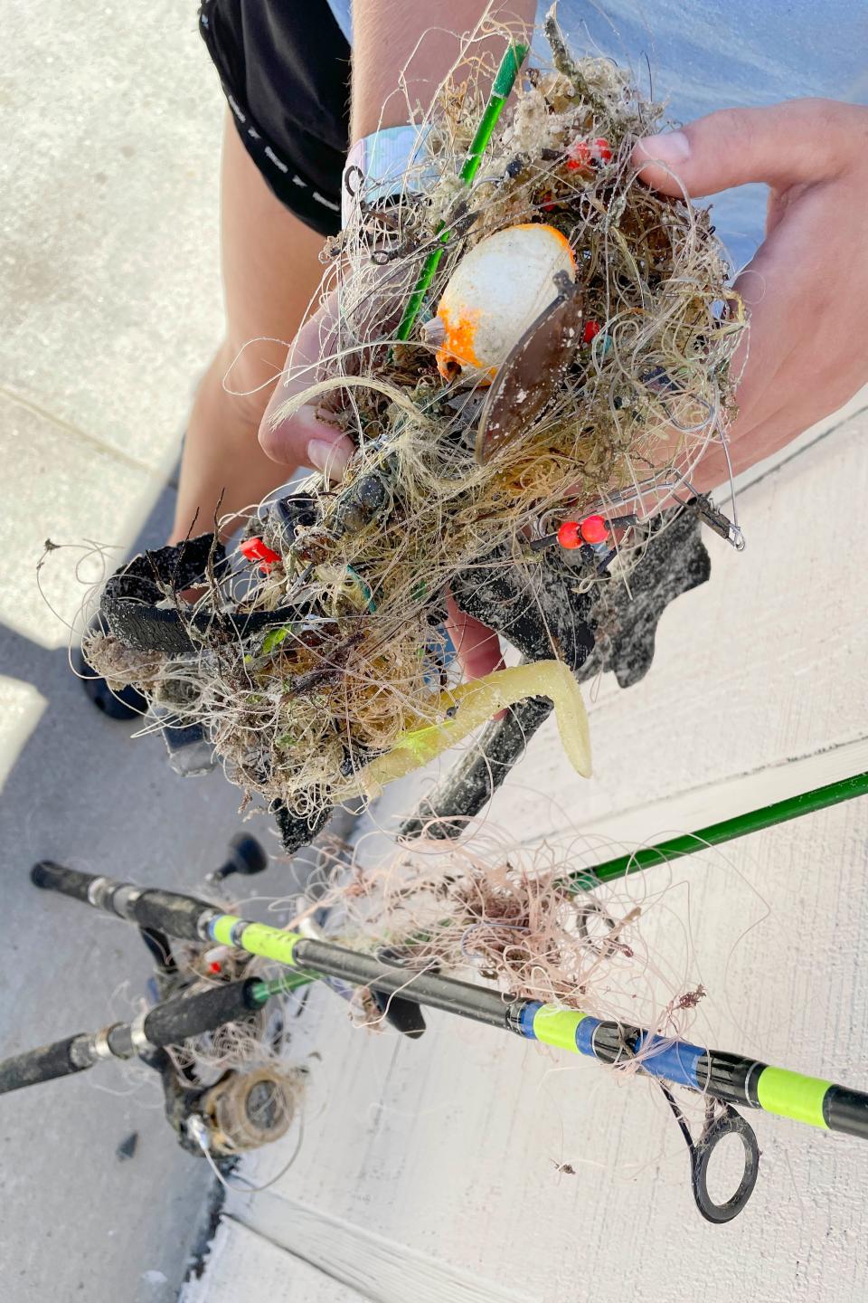 Tabitha Siegfried, sea turtle stranding coordinator the Gulfarium C.A.R.E. Center, holds some of the debris that was taken off of a 217-pound female loggerhead sea turtle that was rescued at the Okaloosa Island Pier on July 5. The material included 5.5 pounds of fishing line, hooks, lures and weights, a pair of sunglasses, a piece of tire and two fishing rods.