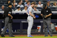 Kansas City Royals relief pitcher Josh Staumont (63) presents his cap and glove to second base umpire Bill Miller after the sixth inning of a baseball game against the New York Yankees, Wednesday, June 23, 2021, at Yankee Stadium in New York. Home plate umpire Gabe Morales (47) watches, left. (AP Photo/Kathy Willens)