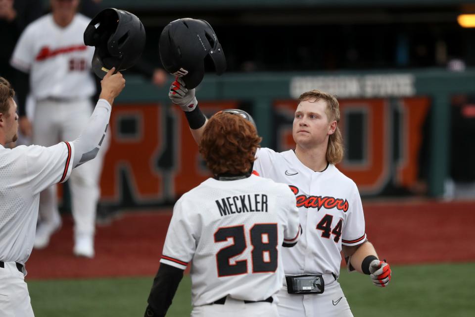 Oregon State's Garret Forrester, right, celebrates his home run against Auburn with Justin Boyd, left, and Wade Meckler, who both scored on the homer, during the first inning of an NCAA college baseball tournament super regional game on Saturday, June 11, 2022, in Corvallis, Ore. (AP Photo/Amanda Loman)