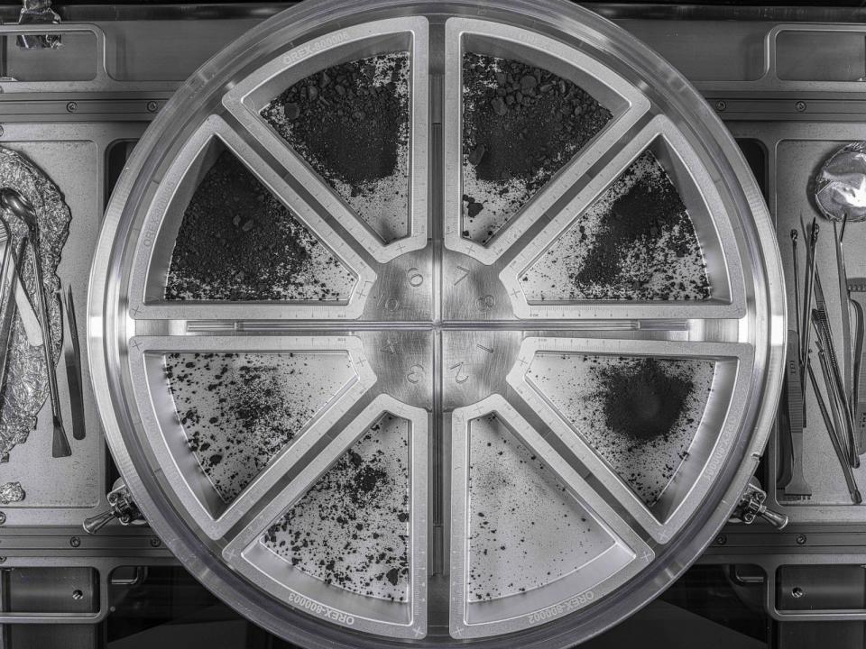 PHOTO: View of eight sample trays containing the final material from asteroid Bennu.  Dust and rocks spilled into trays from the top plate of the Touch and Go Sample Collection Mechanism (TAGSAM) head, January 22, 2024. (NASA/Erika Blumenfeld and Joseph Aebersold)