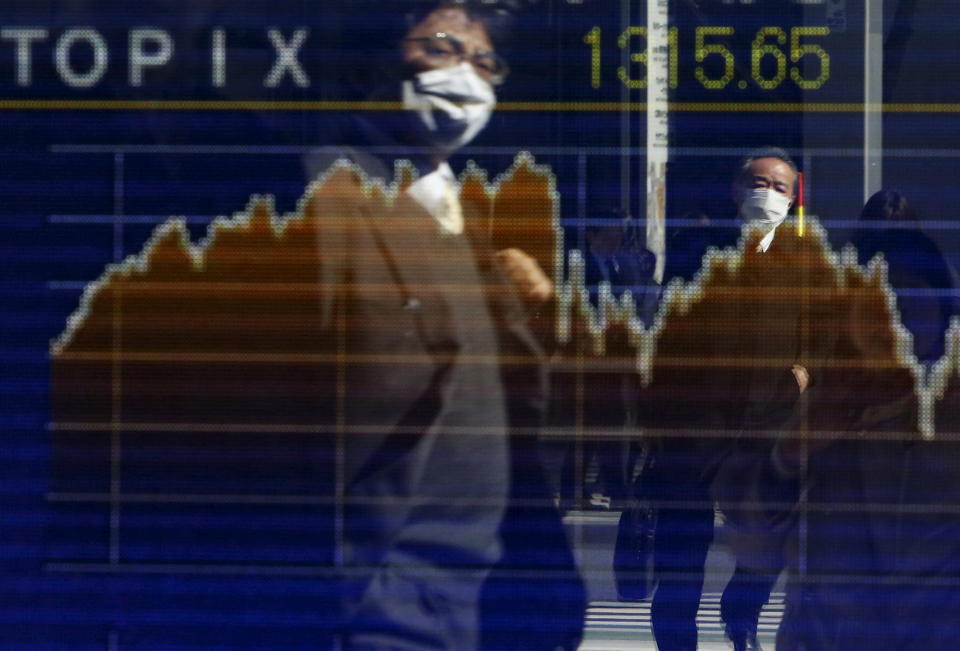 Pedestrians wearing masks are reflected in an electronic board showing the graph of the recent fluctuations of the Tokyo Stock Price Index (TOPIX) outside a brokerage in Tokyo, Japan, February 26, 2016. Asian shares made guarded gains on Friday as a gathering of world finance leaders provided a welter of reassuring comments, but little in the way of actual policy stimulus. REUTERS/Yuya Shino      TPX IMAGES OF THE DAY     