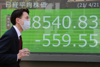 A man walks by an electronic stock board of a securities firm in Tokyo, Wednesday, April 21, 2021. Shares skidded in Asia on Wednesday after Wall Street closed lower for a second straight day, led by drops in technology companies and banks. (AP Photo/Koji Sasahara)