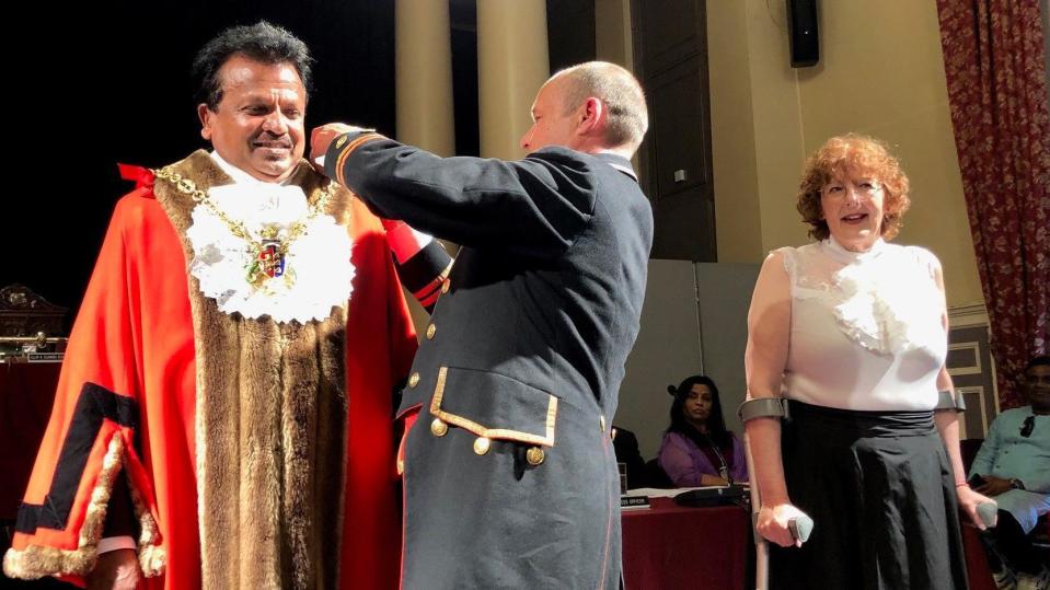 Town sergeant Andrew Beal dresses the new mayor in robes and chain